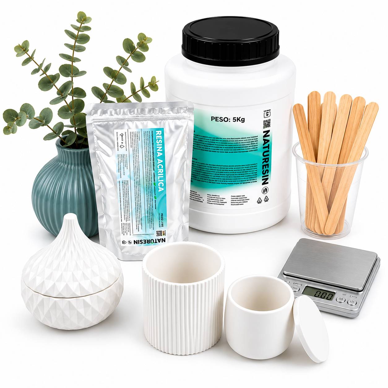 Acrylic resin kit with ceramic containers, wooden mixing sticks, digital scale and eucalyptus decor on a clean white background