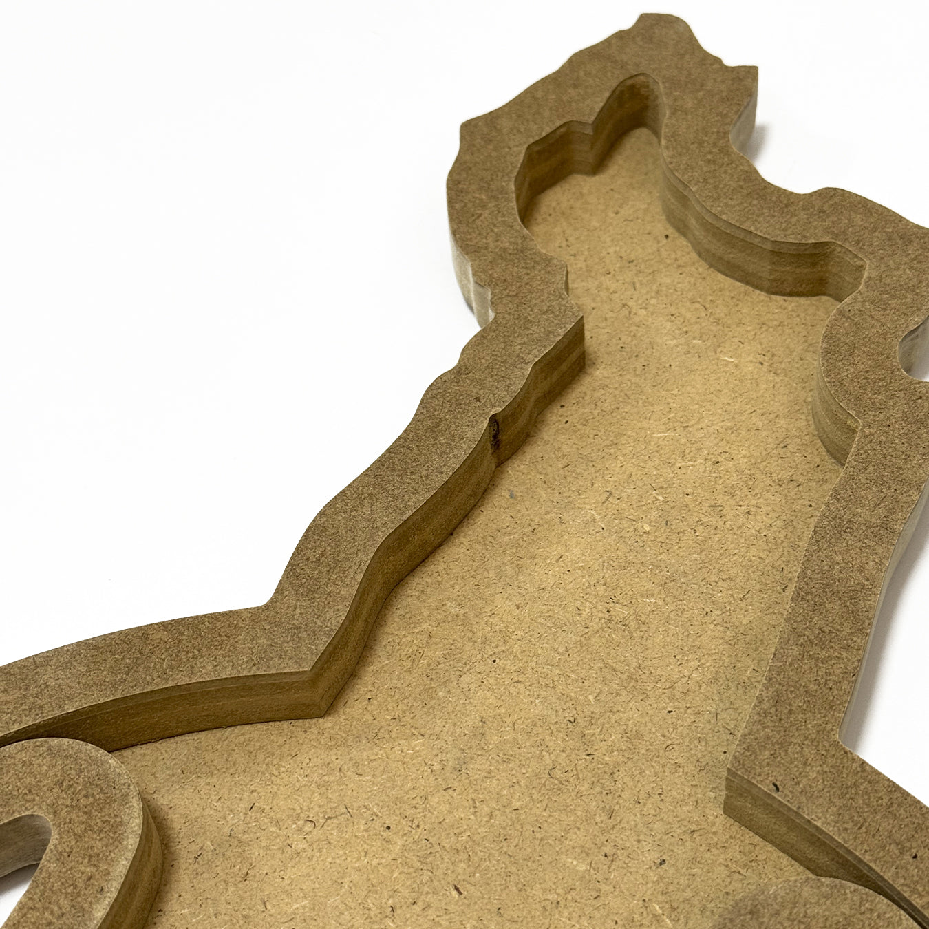 Close-up of a textured brown cardboard cutout with intricate shapes on a white background thumbnail - 4